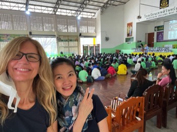 Kelly, Zippy at Thepsurin school near Chiang Mai. Joel sharing the Gospel in the background.