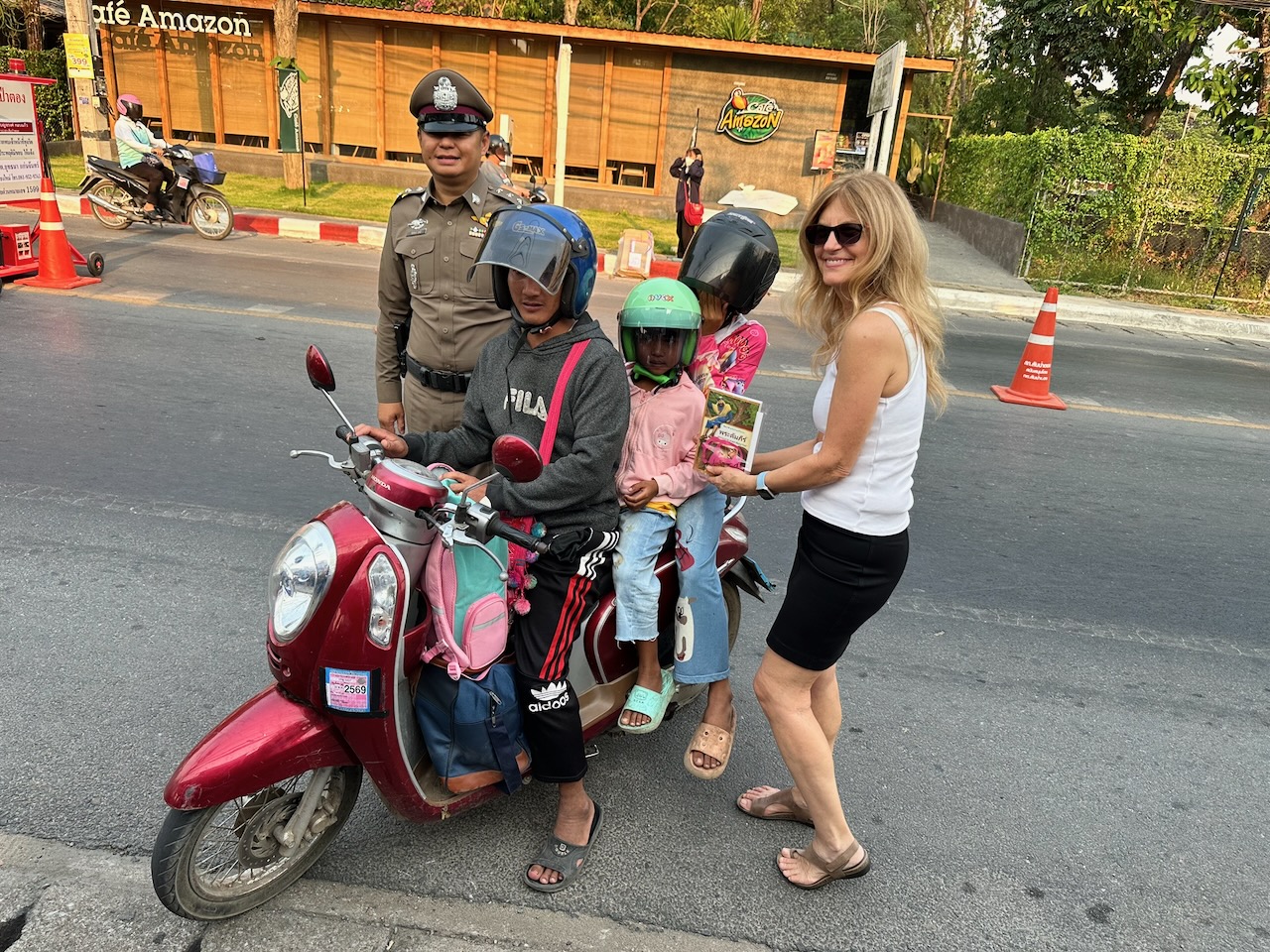 Kelly giving a children's helmet & New Testament to child at police check point